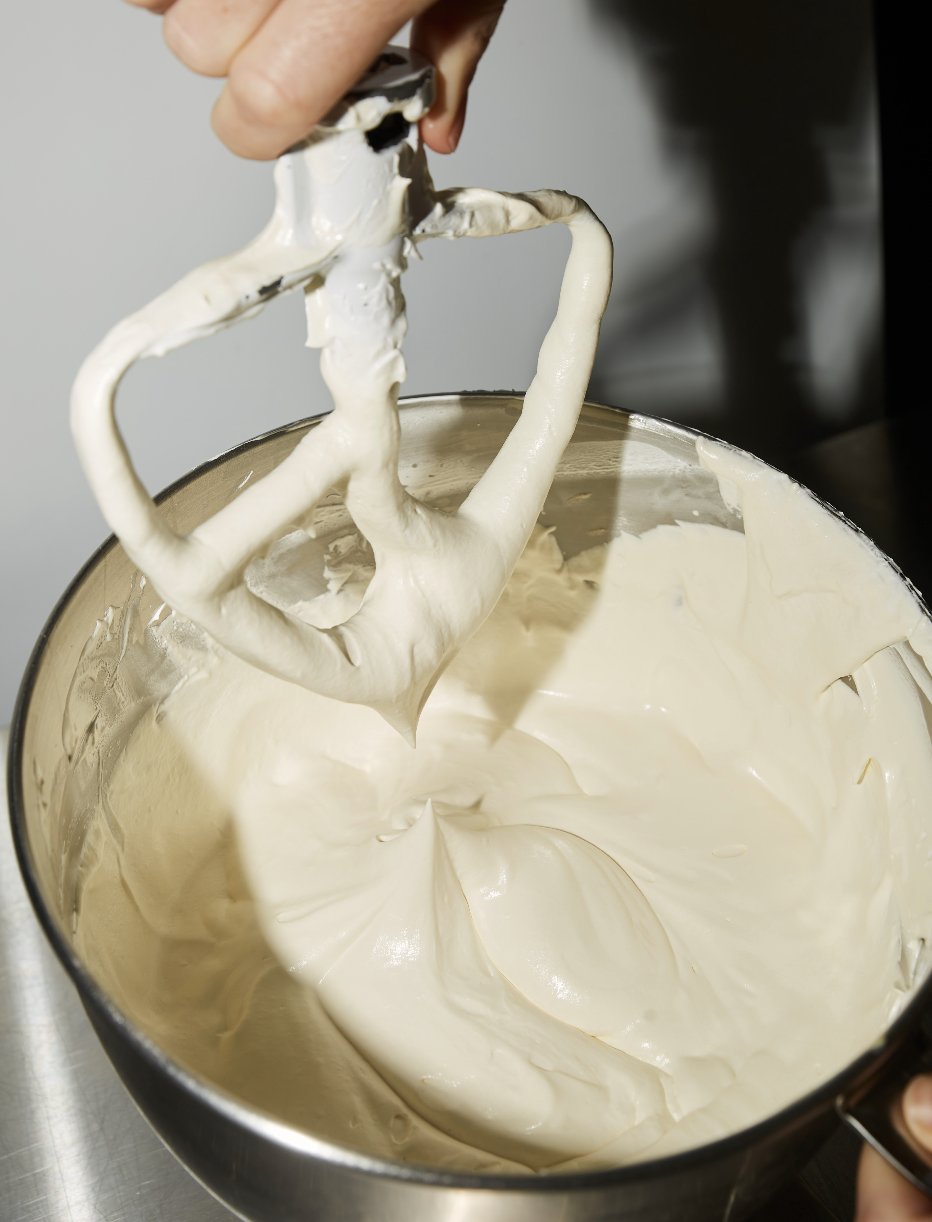Brooki buttercream being piped onto a cake