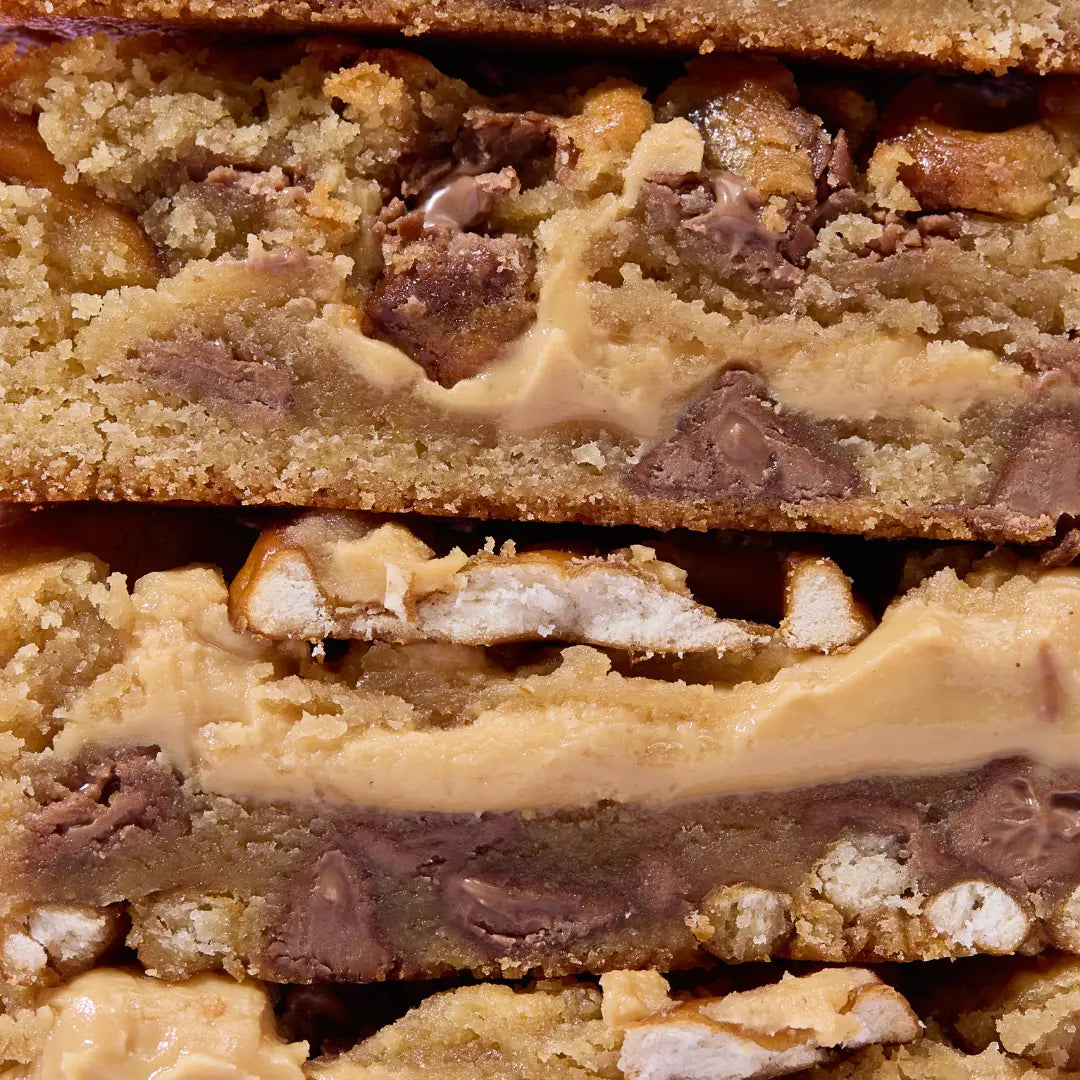 Close-up of a layered cookie bar with chocolate chips and nuts